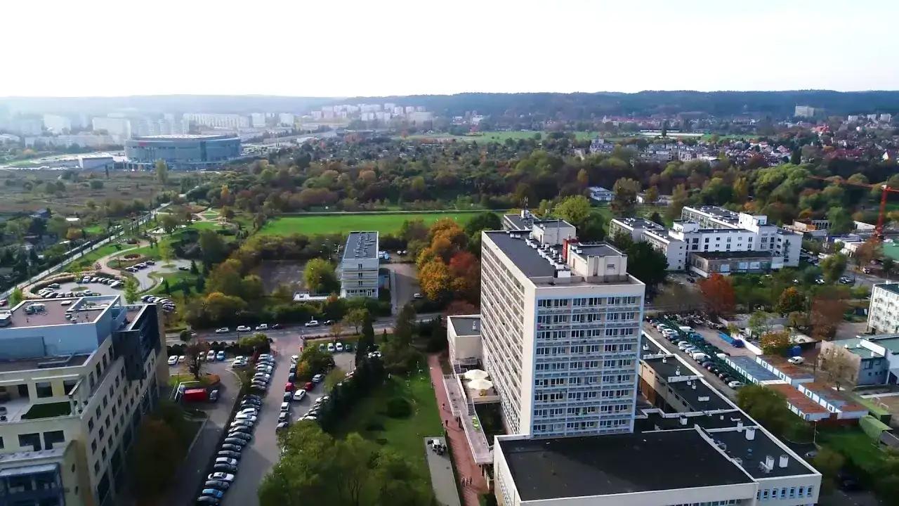 Widok z lotu ptaka na sanatorium MSWiA Sopot. Otoczone zielenią i parkingami, z widokiem na miasto i stadion.