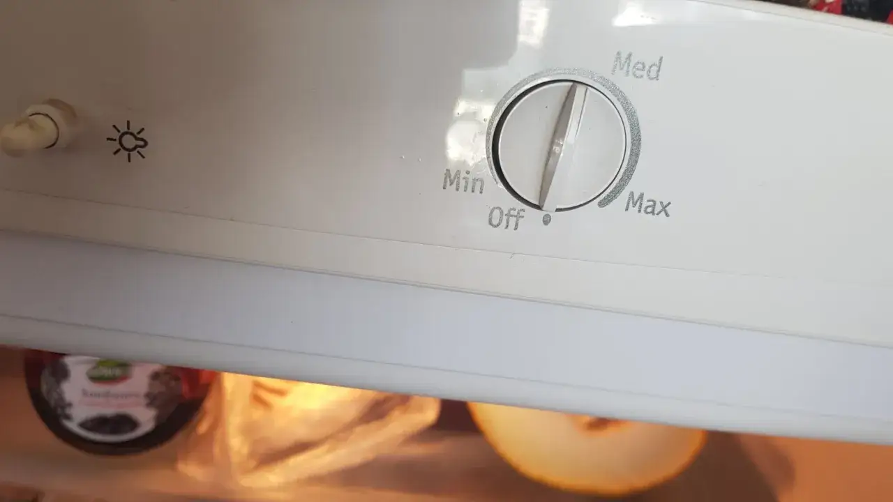 Pokrętło lodówki Whirlpool do ustawienia temperatury: Min, Off, Med, Max. Obok symbol żarówki.