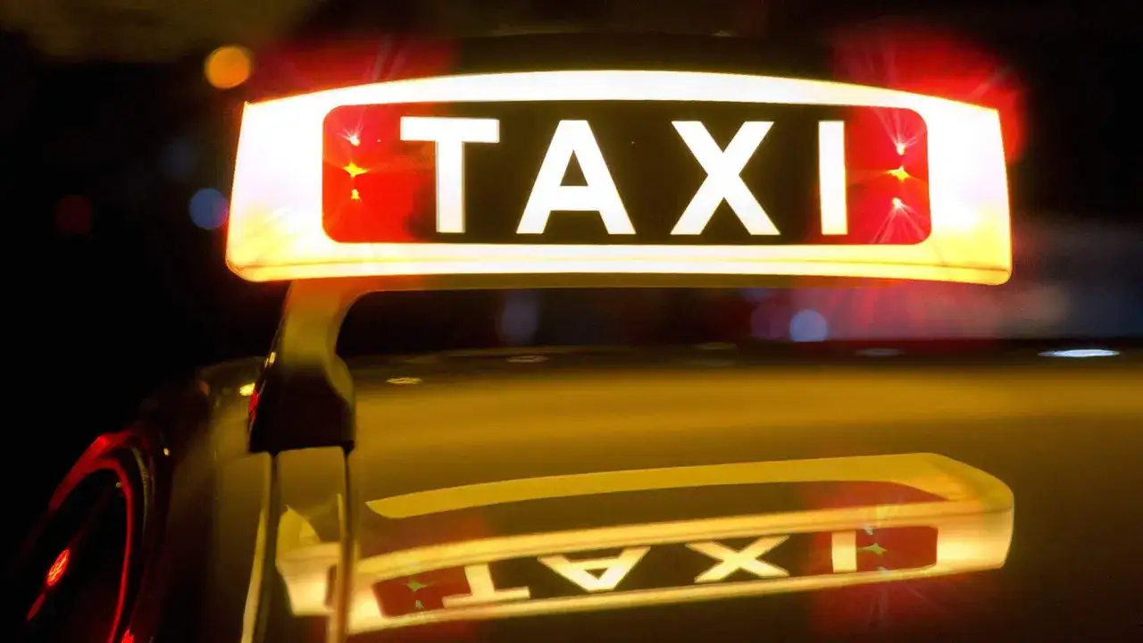 Leuchtendes TAXI-Schild mit roten Blinklichtern, das einen Taxi-Alarm signalisiert.