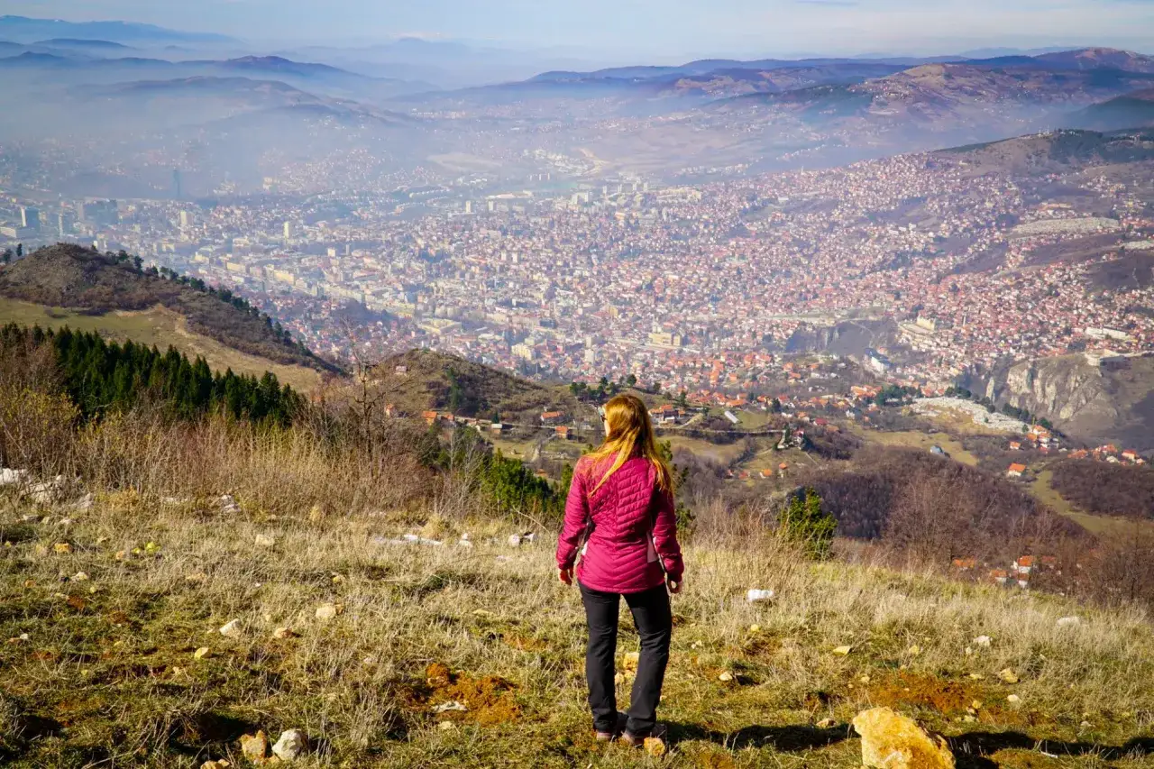 Widok na Sarajewo z góry. Kobieta podziwia panoramę miasta, odkrywając co zobaczyć w Sarajewie.