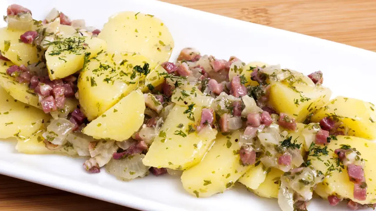 Deliciosa ensalada alemana con patatas cocidas, trocitos de bacon y cebolla, aderezada con perejil fresco.
