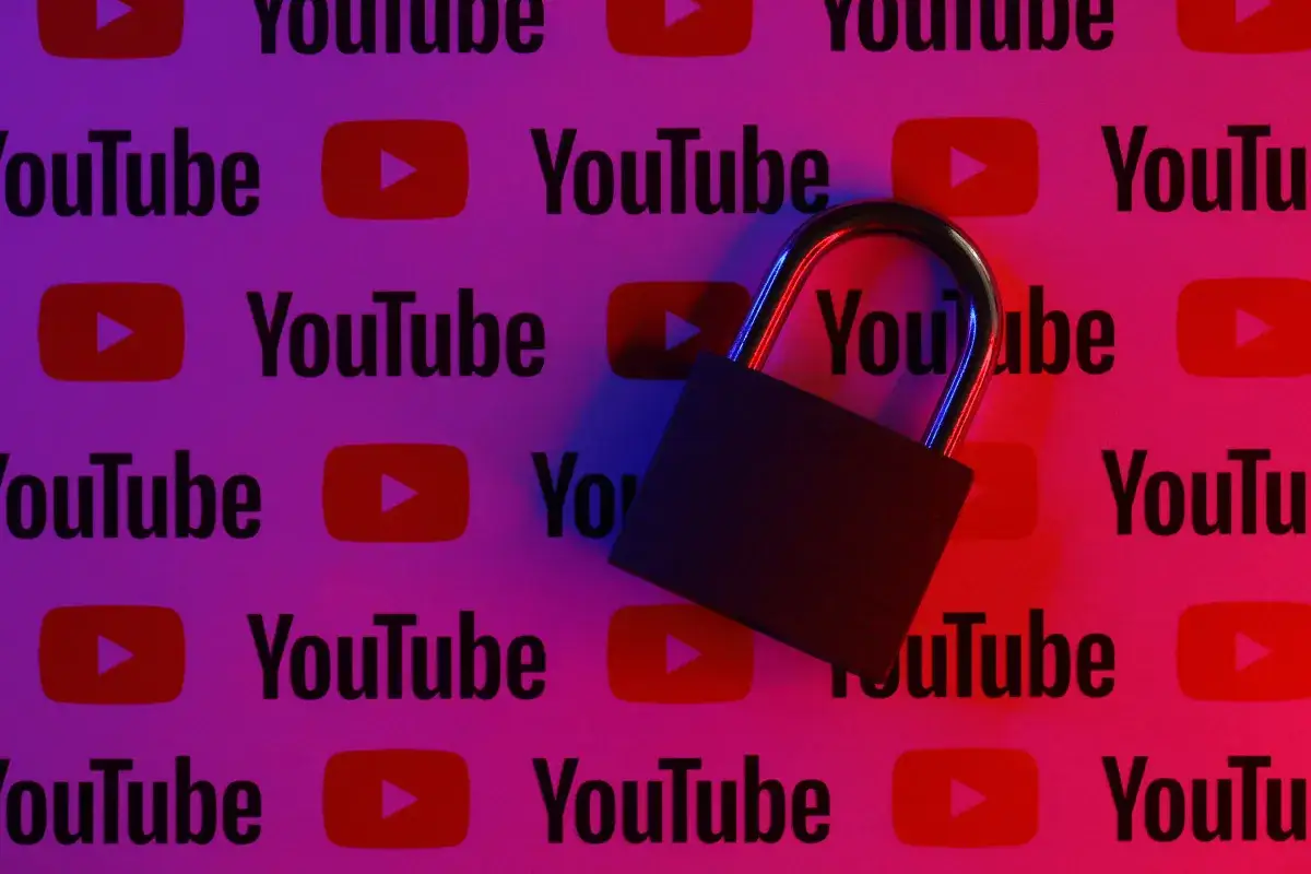 Kłódka na tle logo YouTube. Dowiedz się, jak zablokować YouTube w przeglądarce, aby ograniczyć dostęp.