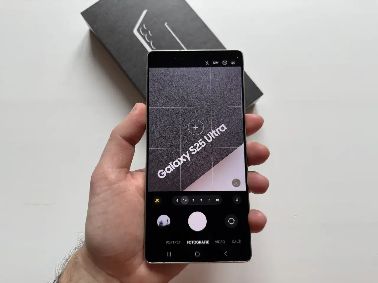 Ręka trzyma Samsunga Galaxy S25 Ultra z włączonym aparatem. Dowiedz się, jak poprawić jakość aparatu w telefonie Samsung.