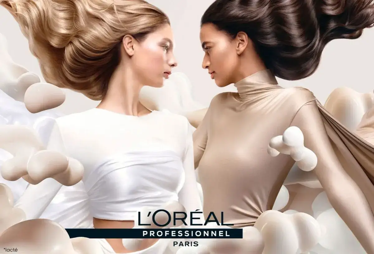 L'Or&eacute;al Professionnel : avant apr&egrave;s, deux femmes aux cheveux &eacute;clatants, l'une blonde, l'autre brune, entour&eacute;es d'&eacute;l&eacute;ments laiteux.