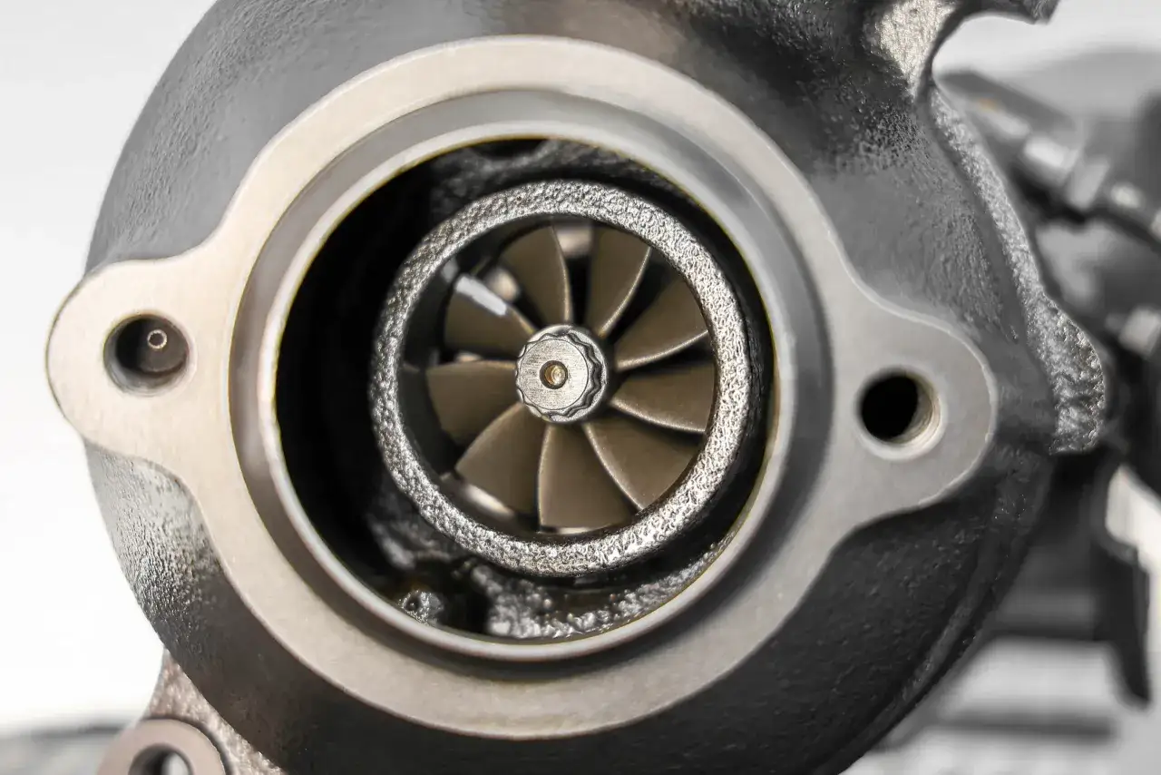 Widok turbosprężarki z widocznymi uszkodzeniami na krawędzi wirnika. Uszkodzony wirnik turbiny objawy mogą być r&oacute;żne, ale tutaj widać fizyczne uszkodzenie łopatek.