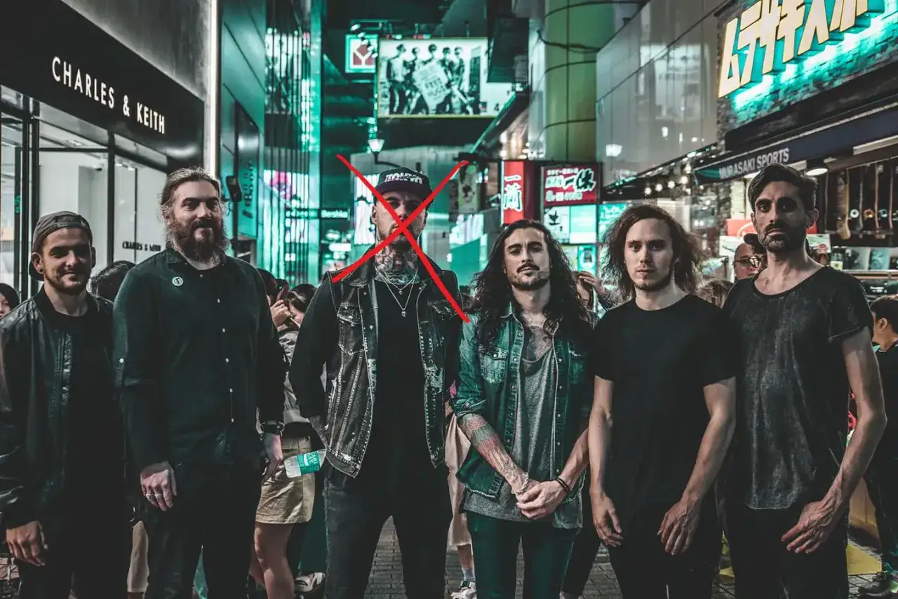 Six hommes posent dans une rue anim&eacute;e de Tokyo, un X rouge sur l'un d'eux, trahissant les martyrs.