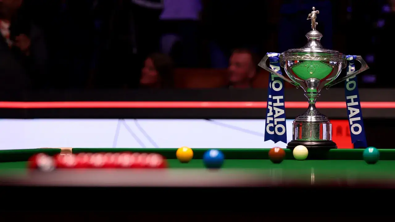 Trofeum snooker mistrzostwa świata na zielonym suknie, otoczone kulami.