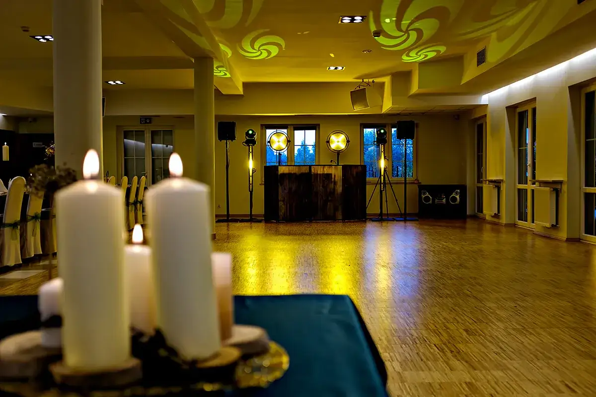 Przygotowana sala weselna z oświetleniem i sprzętem DJ-a. Zastanawiasz się, ile bierze DJ za wesele? Tutaj wszystko gotowe do zabawy!