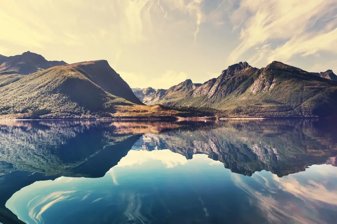 Spiegelglatte Fjorde und majestätische Berge, ein idyllisches Bild von Skandinavien im Sommer.