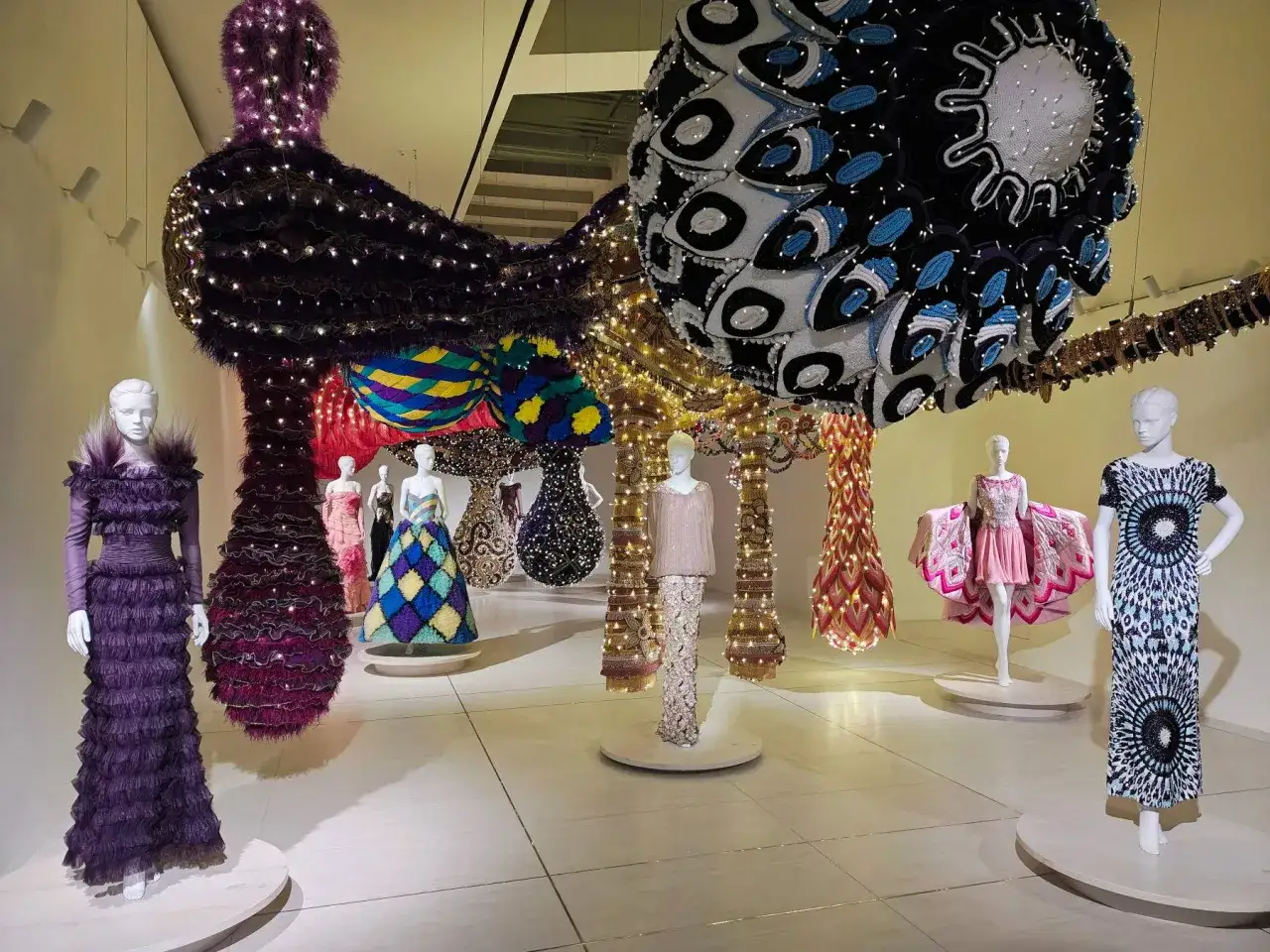 Installazione di moda mostra Valentino Roma: abiti spettacolari e sculture luminose creano un'atmosfera magica.