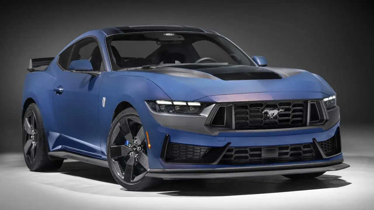 Niebieski Ford Mustang z czarnym spojlerem i felgami z włókna węglowego.