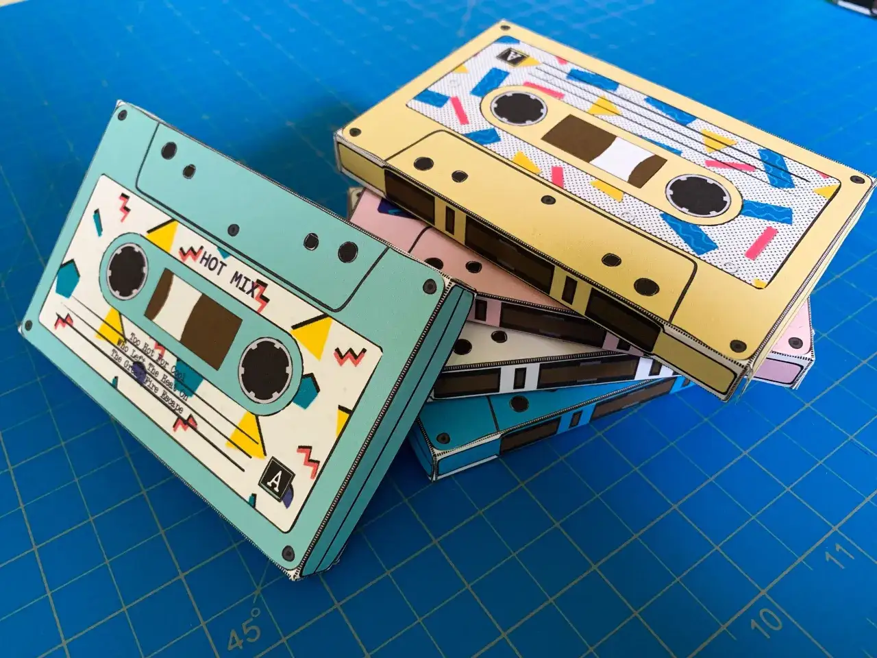 Kolorowe kasety magnetofonowe na niebieskiej macie. Zastanawiasz się, gdzie wyrzucić kasety magnetofonowe? Te retro gadżety mogą trafić do elektrośmieci.