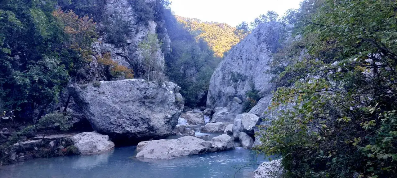 Les gorges de Trévans, un paysage sauvage avec une rivière aux eaux bleues, des rochers imposants et une végétation luxuriante.