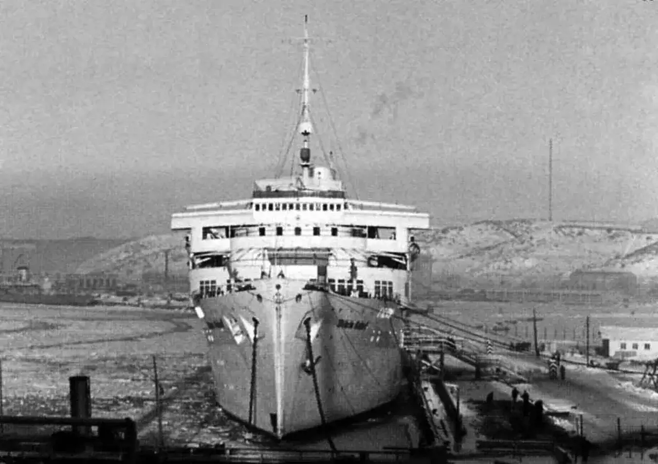 Ogromny statek Wilhelm Gustloff w doku, otoczony lodem i zimowym krajobrazem.