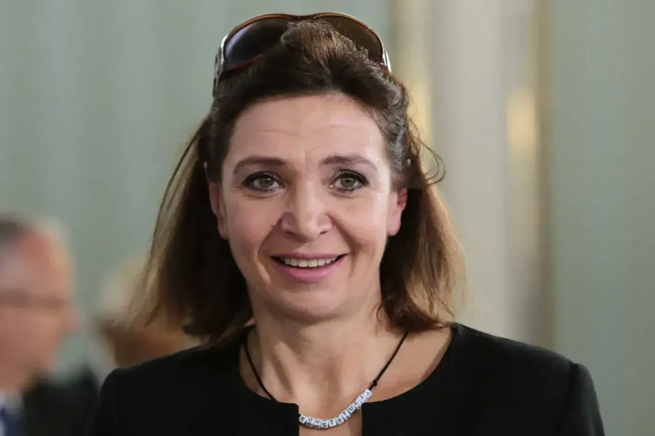 Uśmiechnięta Małgorzata Niemczyk, była siatkarka, w czarnej bluzce i z okularami na głowie.