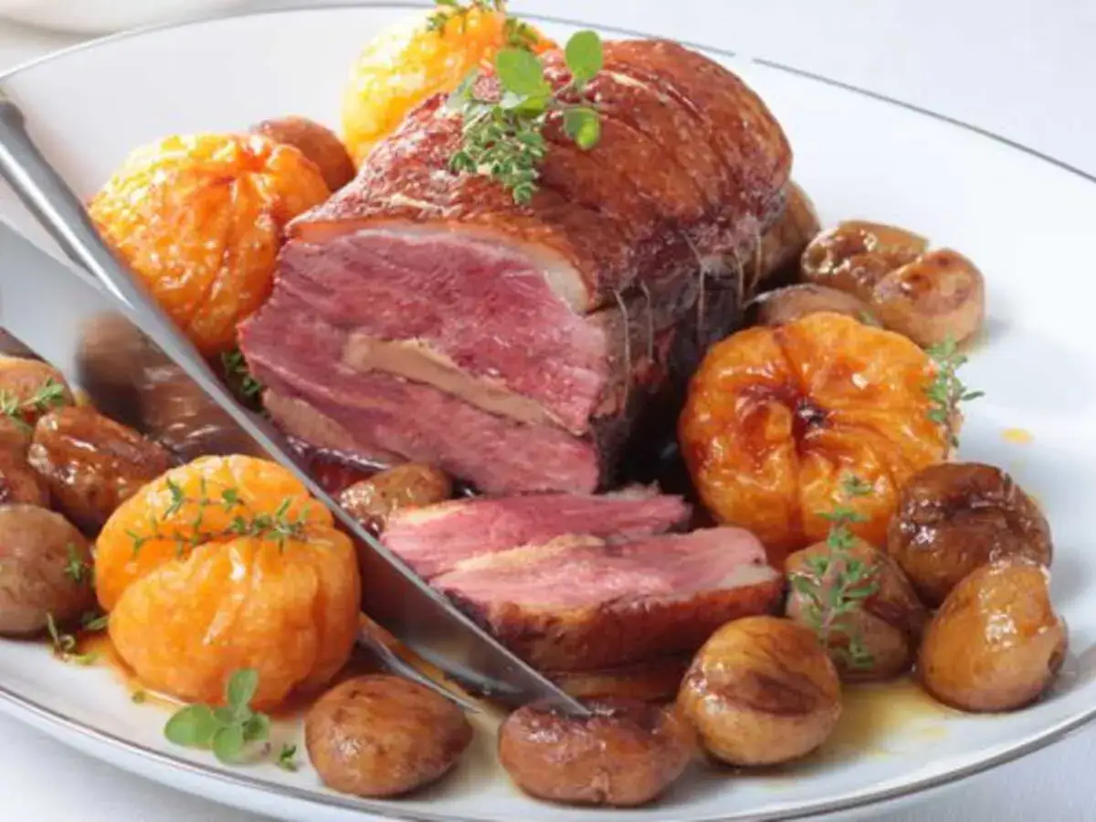 Magret de canard rôti, servi avec des marrons glacés et des quartiers d'orange confite, un accompagnement magret de canard savoureux.
