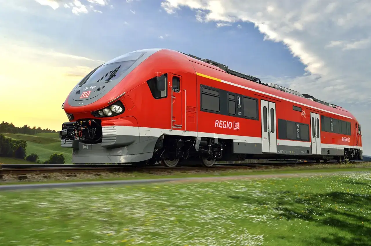 Roter Pesa-Zug der Deutschen Bahn f&auml;hrt durch eine gr&uuml;ne Landschaft.