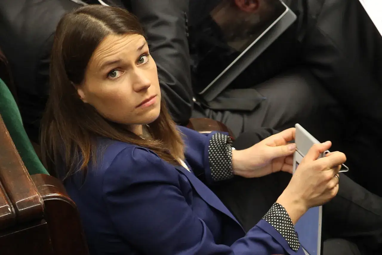 Agnieszka Pomaska w granatowej marynarce, z uwagą słucha, jakby opowiadała rodzicom o swoich wrażeniach.