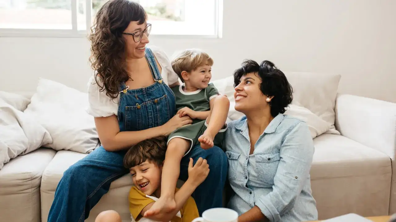 Famiglia felice con due bambini che ridono, un quadro di gioia che smentisce i pensieri sui figli che non si fanno mai sentire.