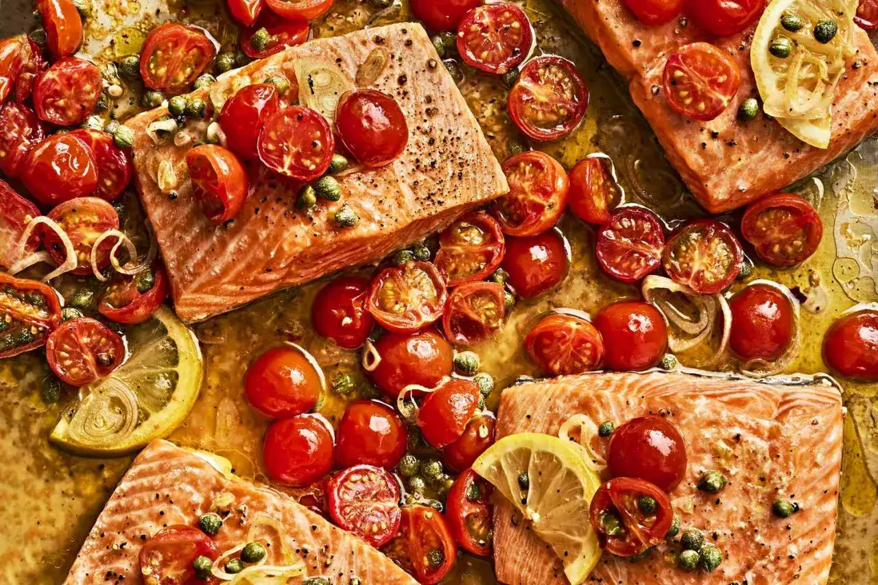 Saftiges Lachsfilet mit gebratenen **cherry tomaten**, Kapern und Zitronenscheiben, alles in einer köstlichen Sauce.
