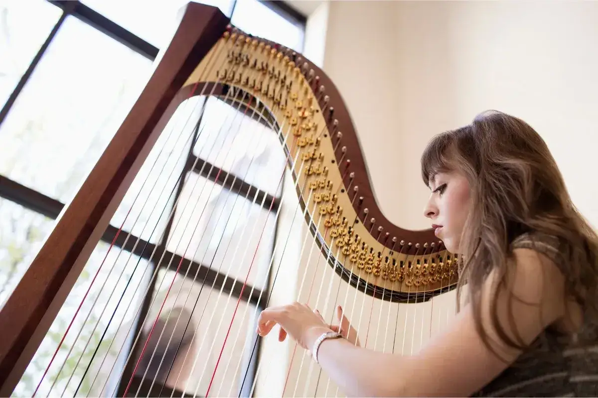 Une jeune femme joue de la harpe, un instrument complexe. Quel est l'instrument le plus difficile &agrave; jouer ? La harpe demande dext&eacute;rit&eacute; et pr&eacute;cision.