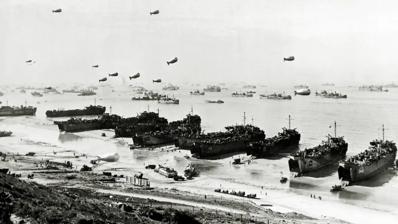 Eine riesige Flotte von Landungsbooten liegt am Strand, während Ballons am Himmel schweben. Dies ist ein Bild, das zeigt, was der D-Day war: eine massive Invasion.