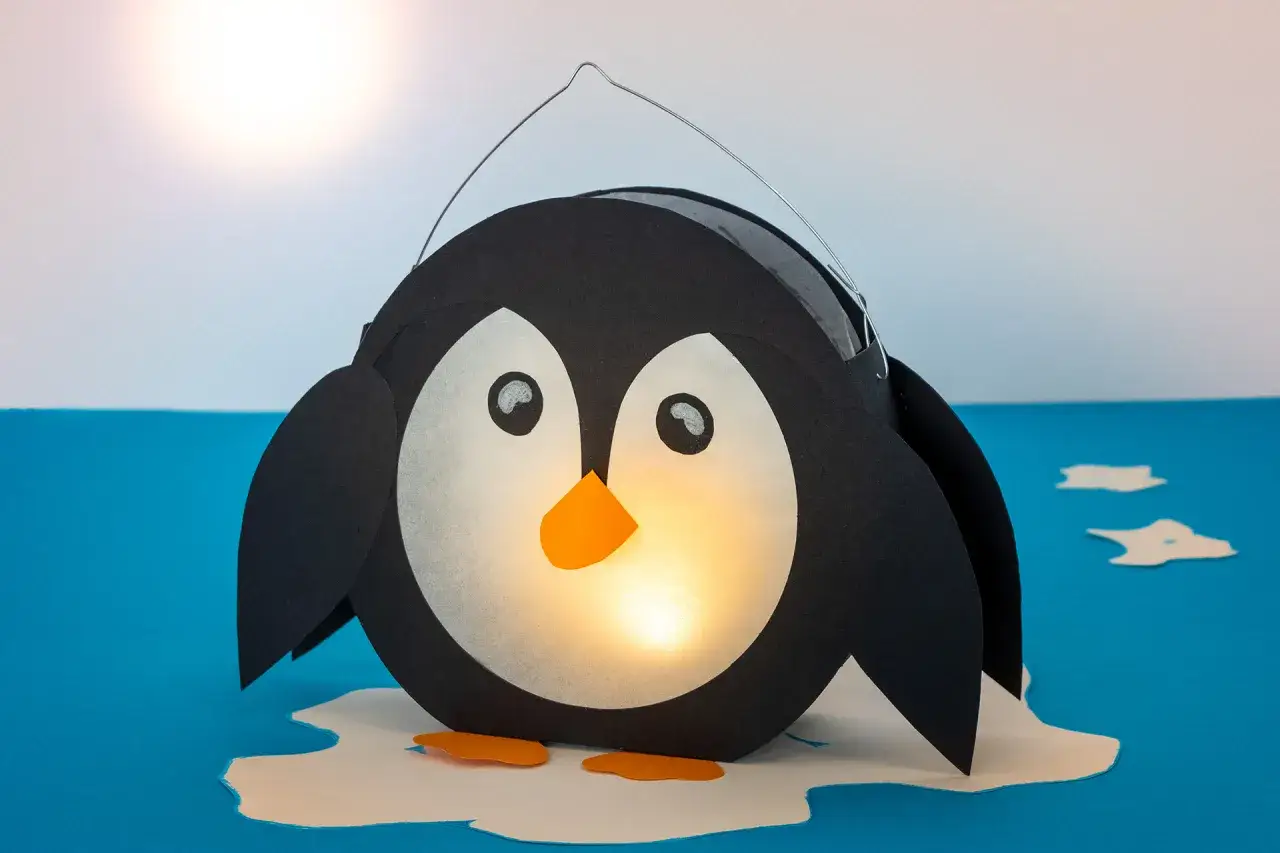 Ein süßer Pinguin, der als Laterne gebastelt wurde, leuchtet warm. Perfekt für den Winter!