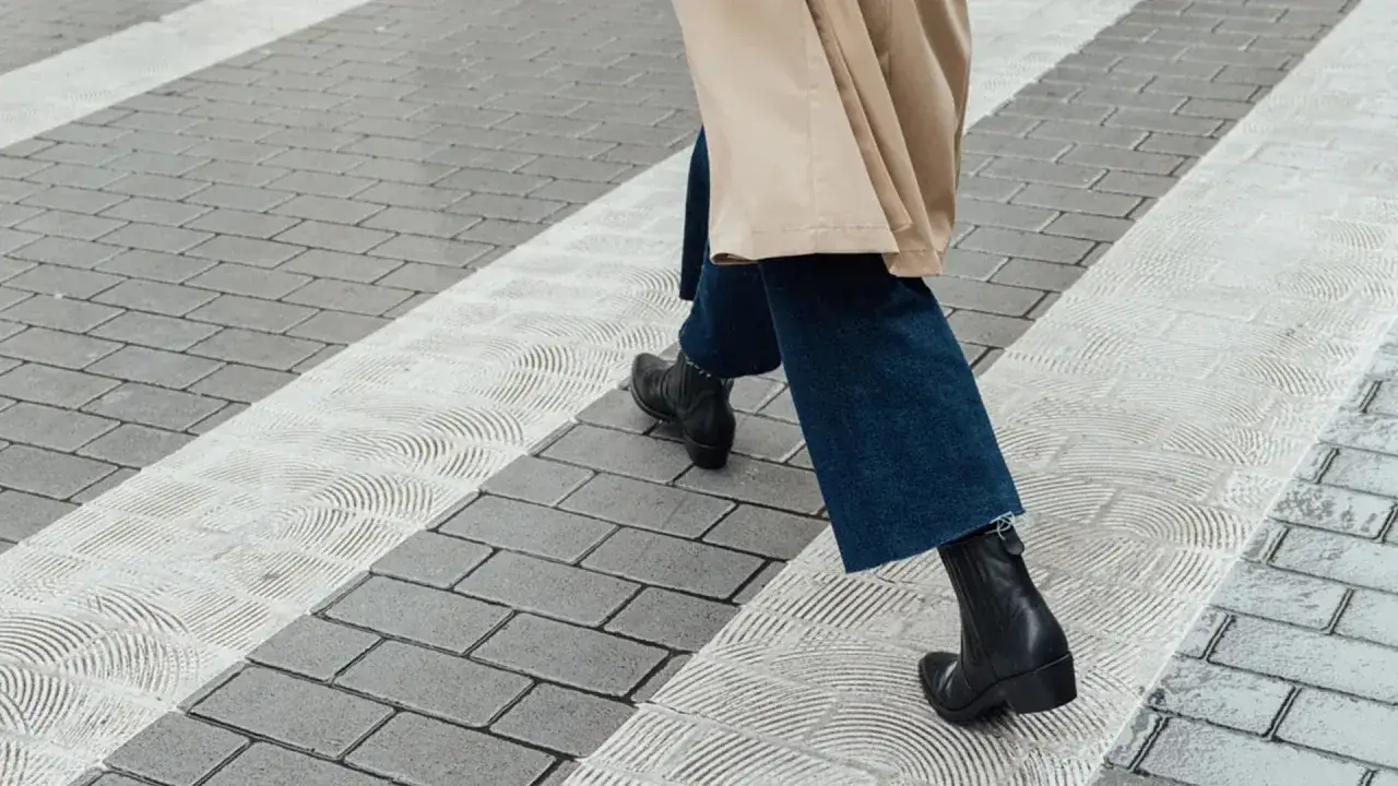 Odkryj, jak nosić spodnie do butów za kostkę, tworząc stylowe, miejskie zestawy. Czarne botki i jeansy prezentują się świetnie na tle miejskiej nawierzchni.