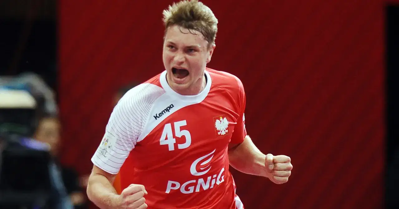 Michał Szyba, zawodnik z numerem 45 na koszulce, krzyczy z radości po zdobyciu bramki.