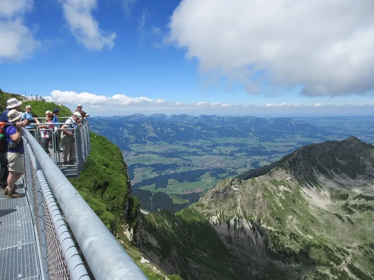 Blick vom Nebelhorn: Wanderer genie&szlig;en die Aussicht auf gr&uuml;ne T&auml;ler und Berge.