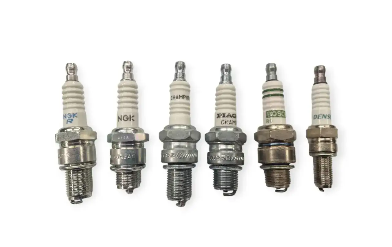 Sei candele per auto: due NGK, Champion, Denso, e due altre marche. Utile per una tabella comparazione candele NGK e concorrenti.