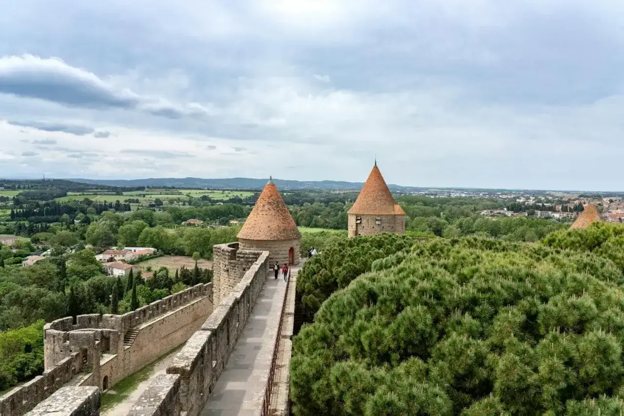 Spacerem po murach Carcassonne, podziwiając stożkowe dachy wież i zielone krajobrazy.
