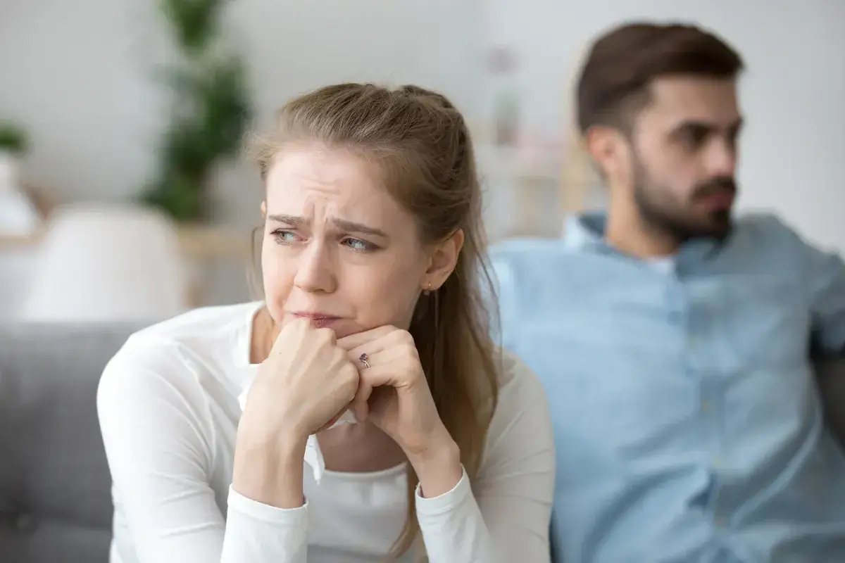 Una donna piange, con un fazzoletto in mano, mentre un uomo le volta le spalle. Potrebbe essere il rimpianto di qualcuno.