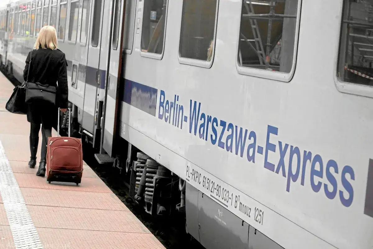 Kobieta z walizką na peronie czeka na pociąg Berlin-Warszawa-Express. Zastanawia się, ile kosztuje pociąg do Berlina.