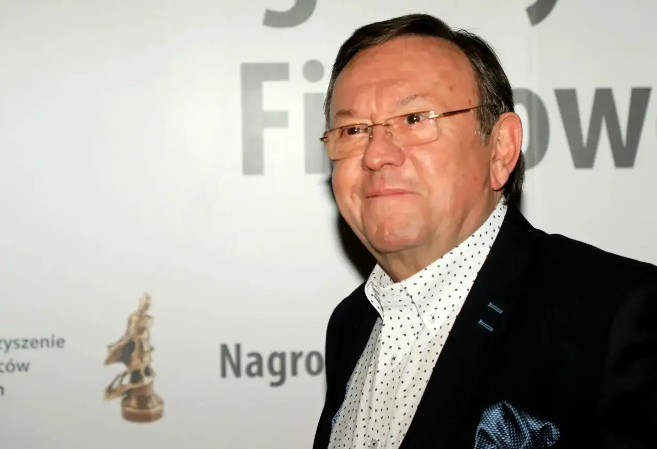 Zbigniew Buczkowski, znany z licznych **filmów, seriali i programów**, w eleganckim garniturze i z nagrodą filmową.