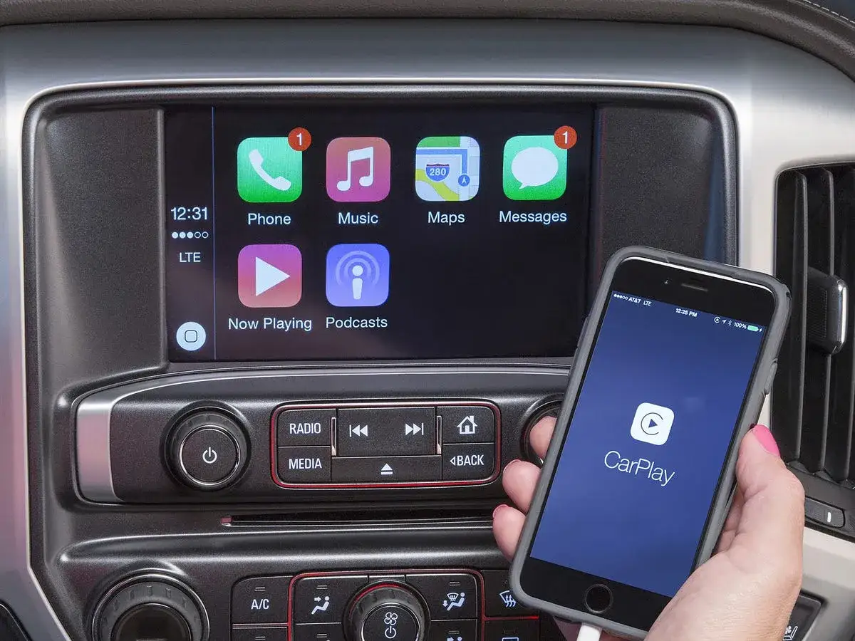 Podłącz iPhone'a, aby włączyć Apple CarPlay. Na ekranie widać ikony Phone, Music, Maps, Messages, Now Playing i Podcasts.
