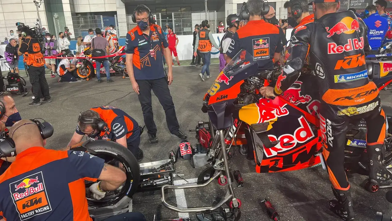 Mec&aacute;nicos del pit lane MotoGP trabajan en una moto KTM Red Bull.