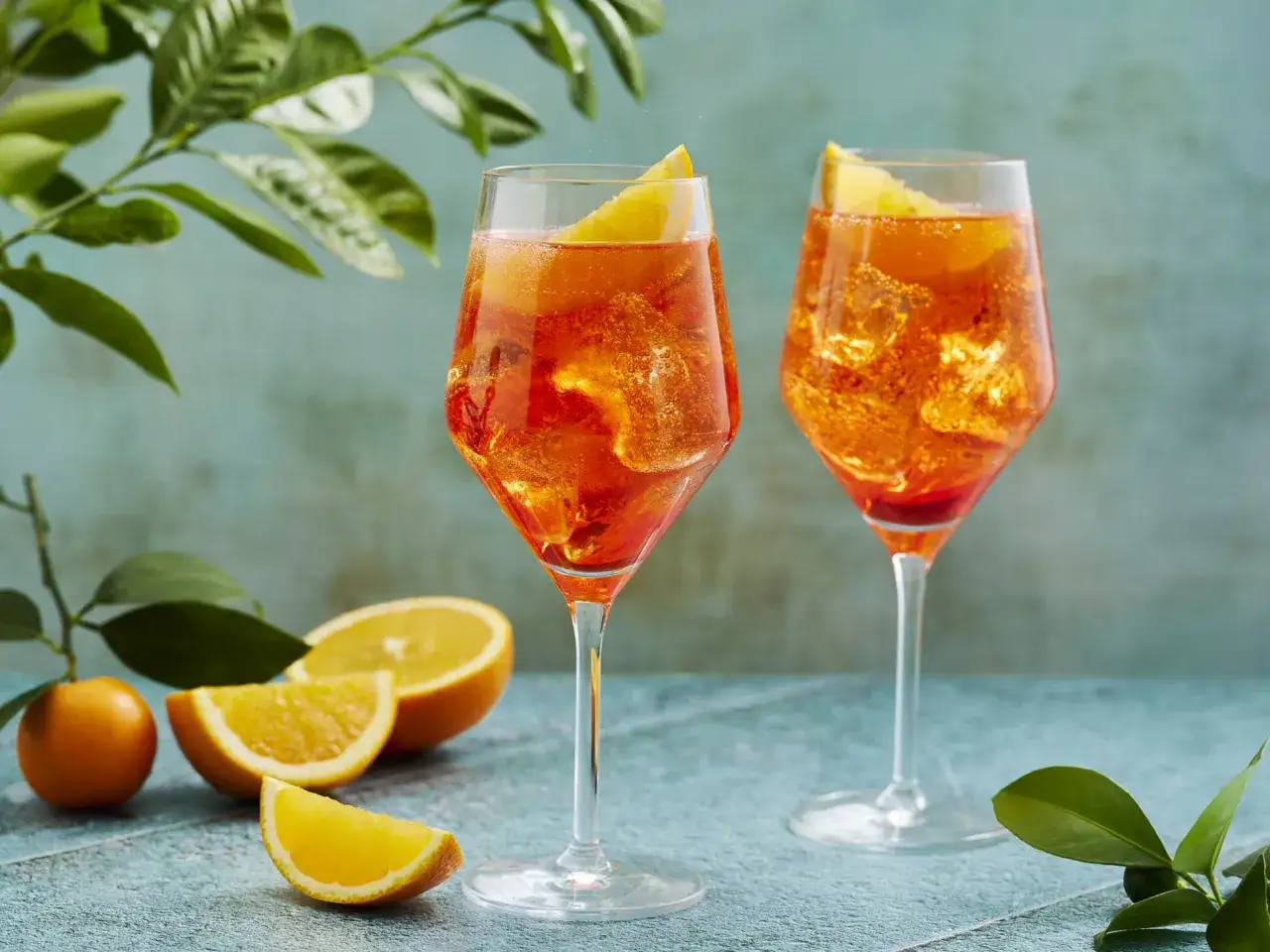 Zwei Aperol Spritz Gläser mit Eis und Orangenscheiben. So einfach wie man Aperol Spritz macht!