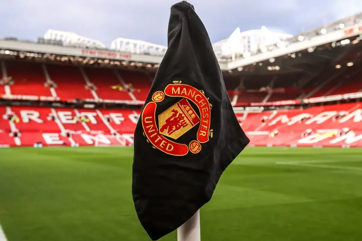 Flaga Manchester United na tle stadionu. Fani spekulują o przyszłych manchester united transfery.