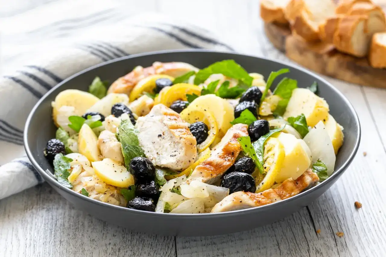 Insalata di pollo sfiziosa con patate, olive nere e limone, un piatto fresco e saporito.