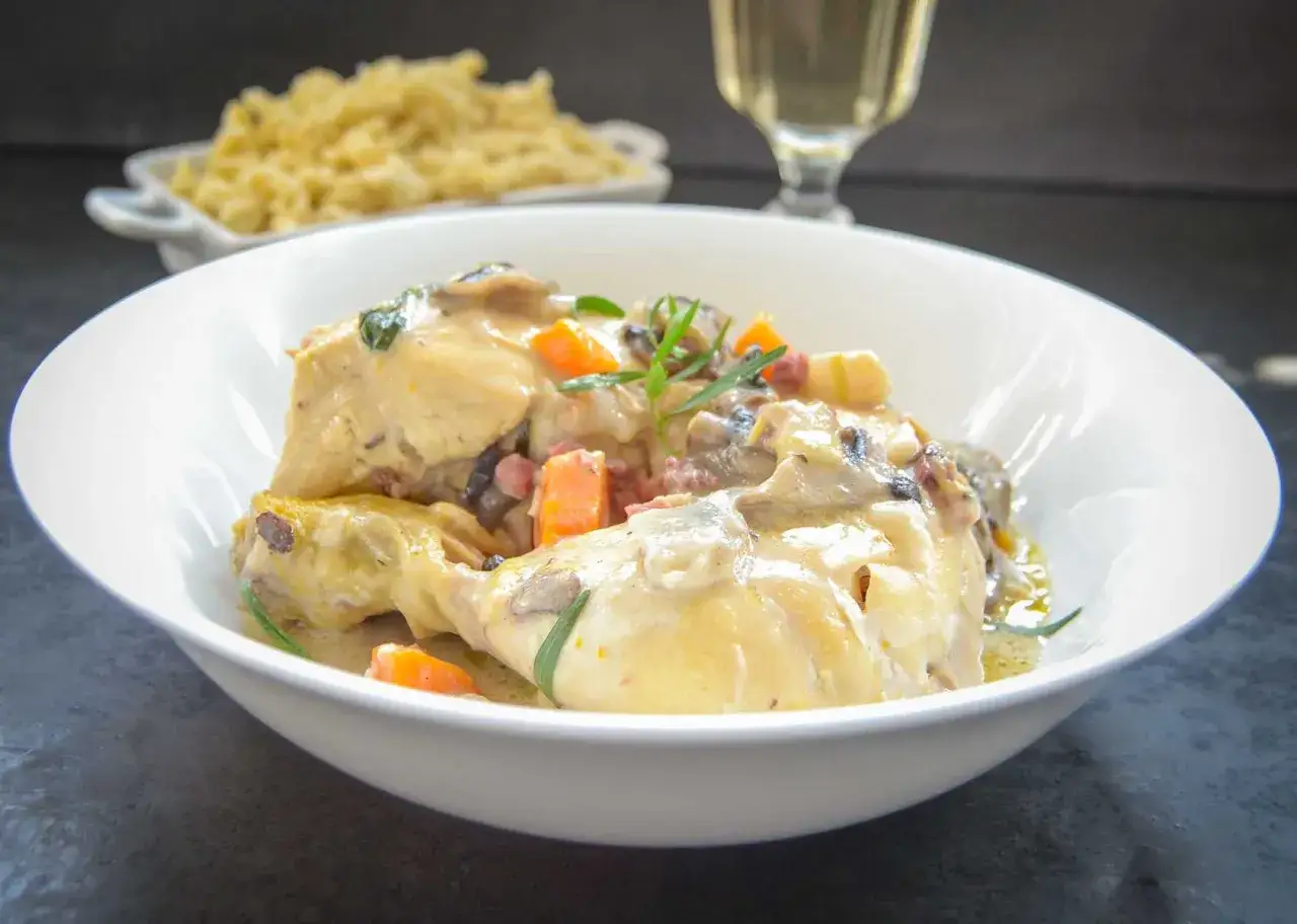 Coq au Riesling nach Martina und Moritz Rezept: Hähnchenteile in cremiger Sauce mit Pilzen und Karotten, dazu Spätzle.