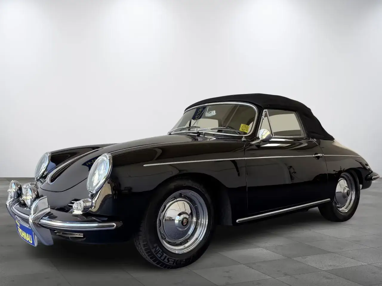 Klasyczny czarny kabriolet Porsche 356 z chromowanymi detalami i złożonym dachem, gotowy na letnią przejażdżkę.