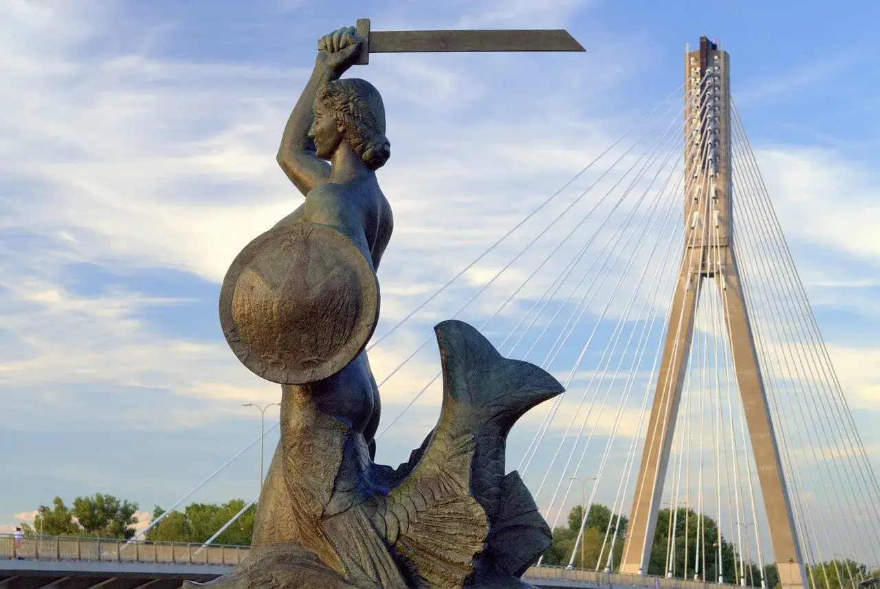 Warszawska Syrenka, bohaterka legendy, z mieczem i tarczą, na tle nowoczesnego mostu.