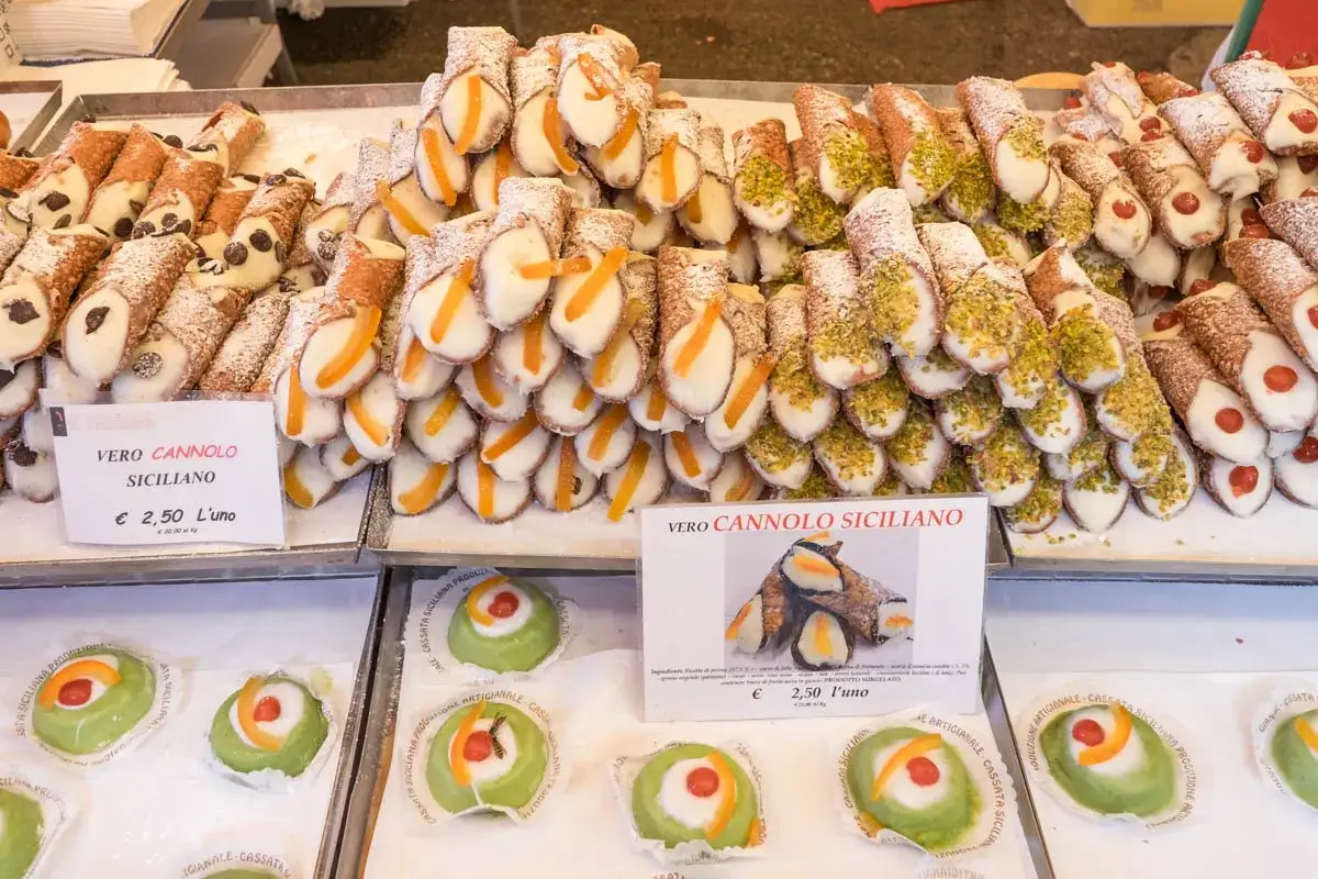Słodkości w Modenie: stosy cannoli sycylijskich z kandyzowanymi owocami i pistacjami, a obok zielone cassate. Idealne na deser!