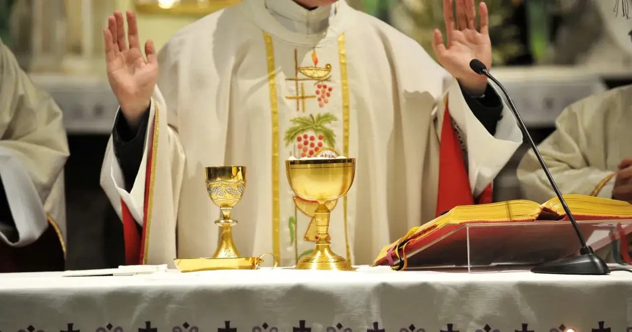 Ks. Witko podczas mszy, jego opinia kościoła jest widoczna w symbolice kielichów i hostii.