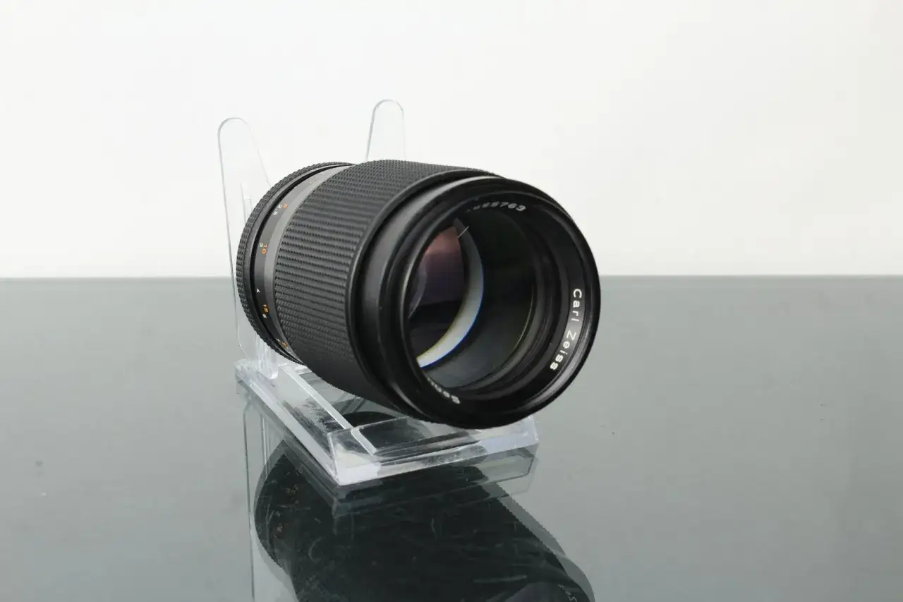 A Carl Zeiss Sonnar 8 lens, a classic piece of photographic equipment, rests on a clear stand, ready for its next creative journey.