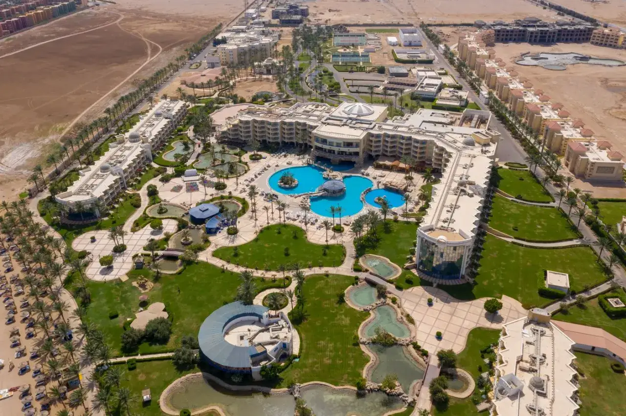 Luksusowy resort Palm Royale Soma Bay z basenami, palmami i plażą.