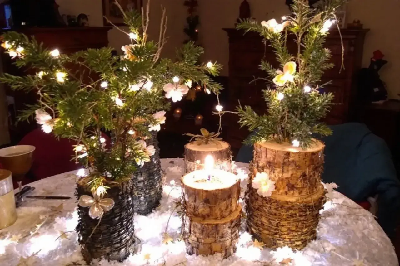 Jolis arrangements de **deco de noel en bois fait maison**, avec des branches de sapin, des guirlandes lumineuses et des fleurs délicates.