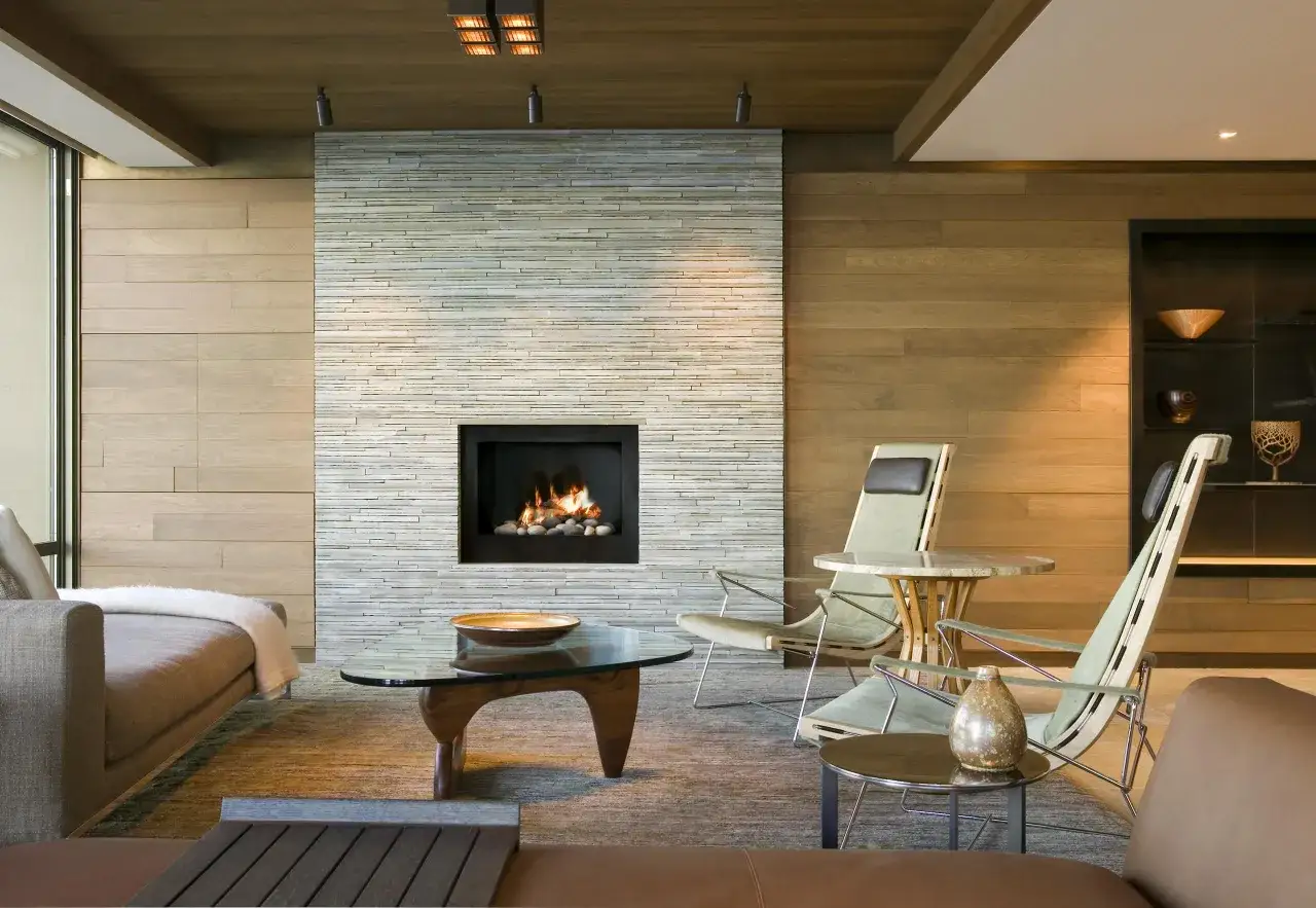 Modern living room with a striking stone **embellecedor chimenea** featuring a gas fireplace.