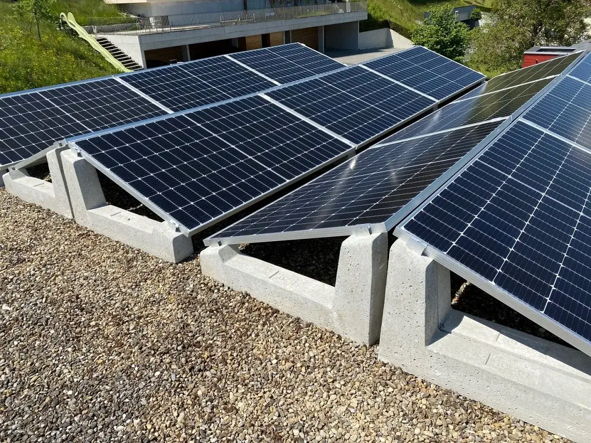 Pannelli fotovoltaici installati su una copertura con ghiaia. L'orientamento dei pannelli è ottimizzato per massimizzare la cattura solare.